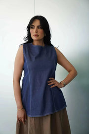 Woman wearing a sleeveless casual jean blouse with relaxed fit and classic stitching details.