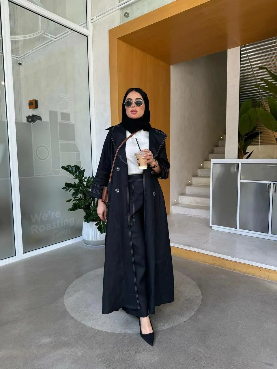 woman wearing black linen blazer with refined tailoring and lightweight fabric standing indoors