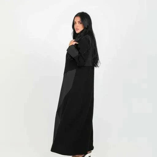 Woman wearing a full-length statement black blazer abaya with geometric crepe fabric panels and a sharp lapel collar