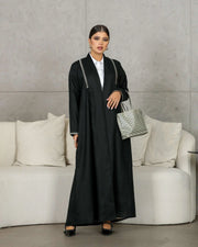 Elegant black abaya made of breathable linen with minimal embroidery and a clean, sophisticated design