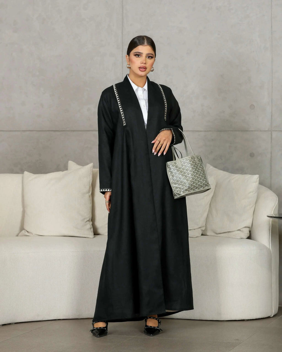 Elegant black abaya made of breathable linen with minimal embroidery and a clean, sophisticated design