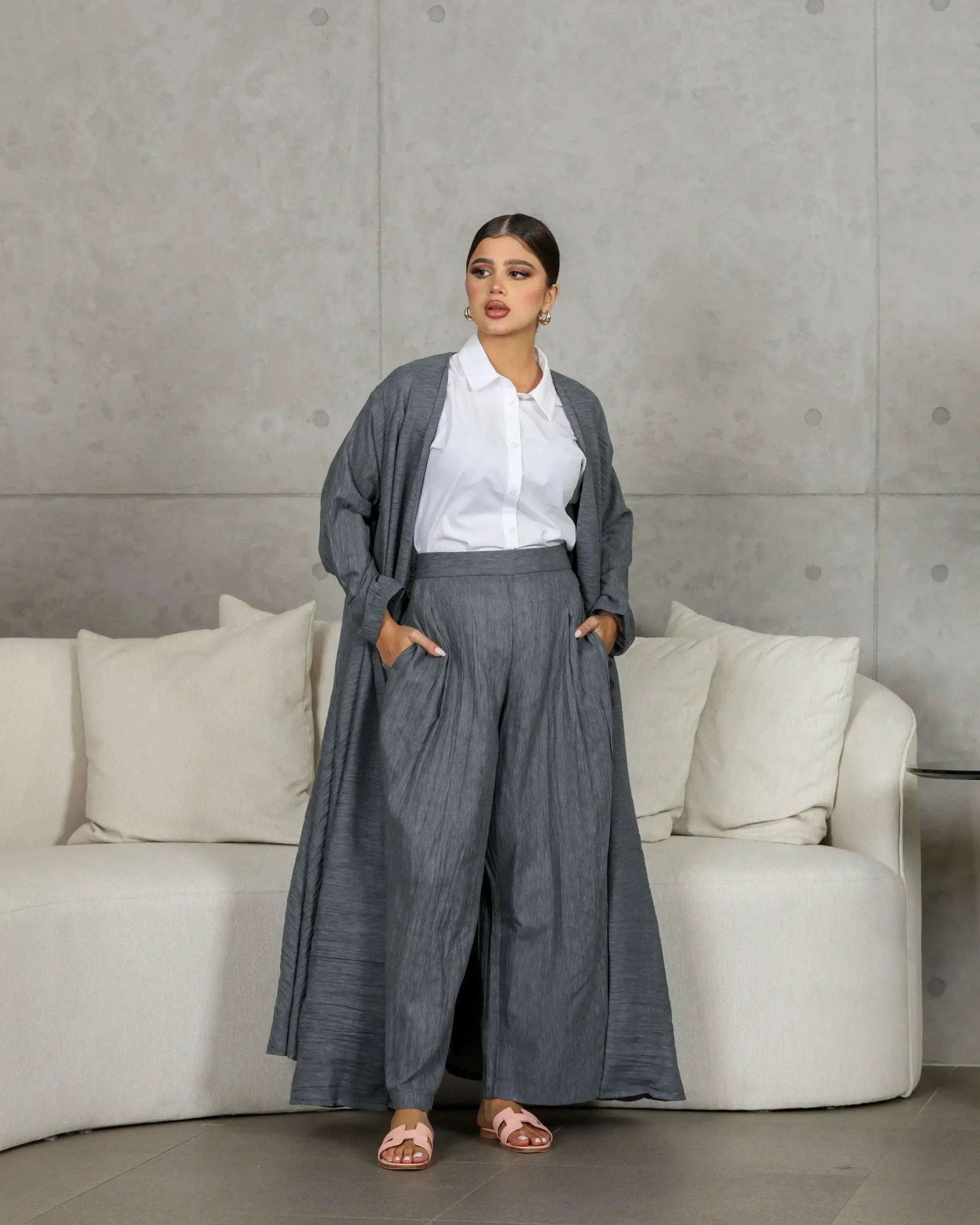 woman wearing gray crumpled linen relaxed-fit outerwear with matching pants and white shirt indoors