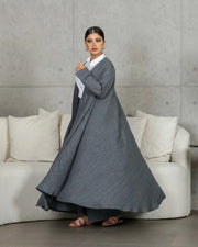 woman wearing gray relaxed-fit outerwear and matching pants with white shirt standing indoors