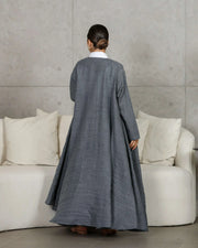 woman wearing gray relaxed-fit outerwear and matching pants with white shirt standing indoors
