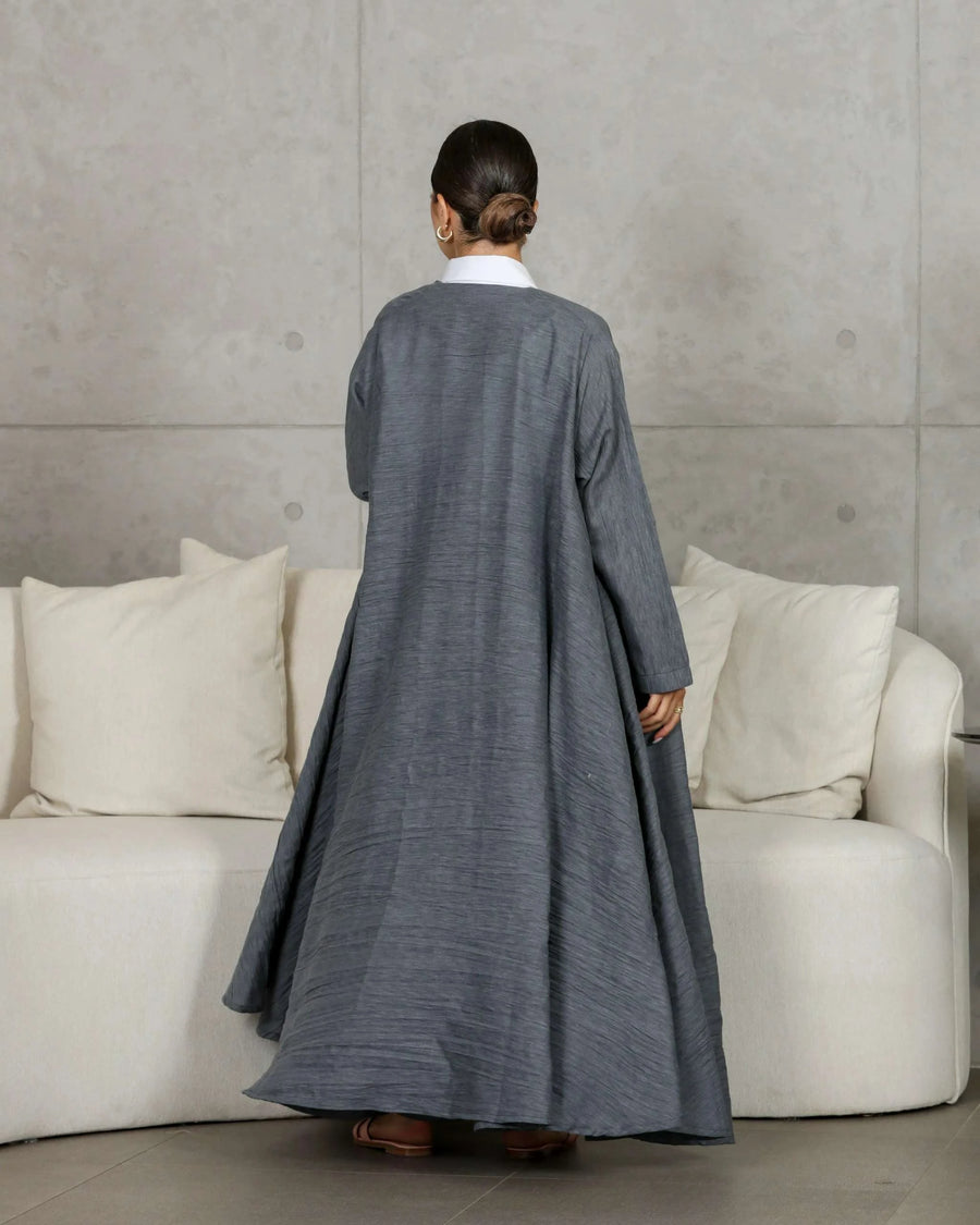 woman wearing gray relaxed-fit outerwear and matching pants with white shirt standing indoors