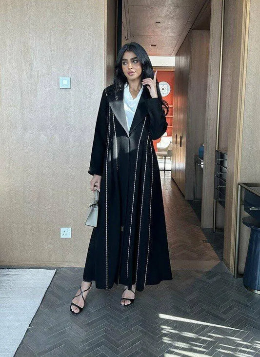Modern black abaya with white line detailing in soft crepe fabric, styled for everyday elegance