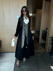 Modern black abaya with layered blazer-style design, wide lapels, and double-breasted buttons, styled for elegant daywear or evening outings
