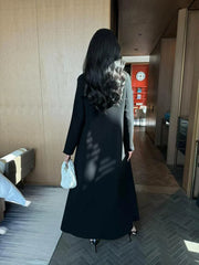 Modern black abaya with layered blazer-style design, wide lapels, and double-breasted buttons, styled for elegant daywear or evening outings