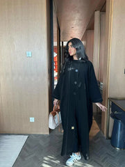 black abaya with button details and straight lines in soft crepe fabric, one-size breathable and modern design