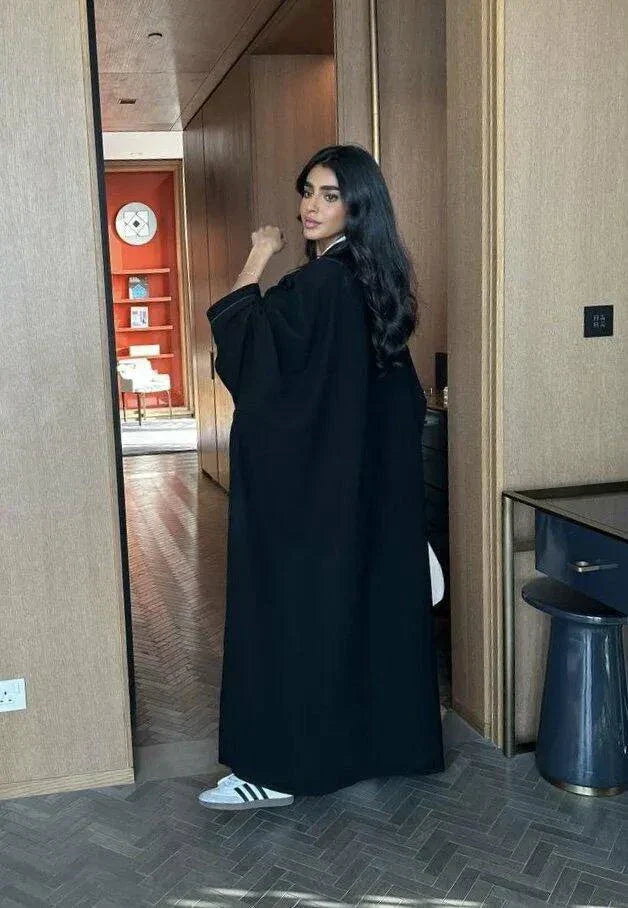 black abaya with button details and straight lines in soft crepe fabric, one-size breathable and modern design
