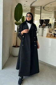Modern black abaya with trench coat design, wide lapels, double-breasted silver buttons, and cuff details for a sophisticated look.