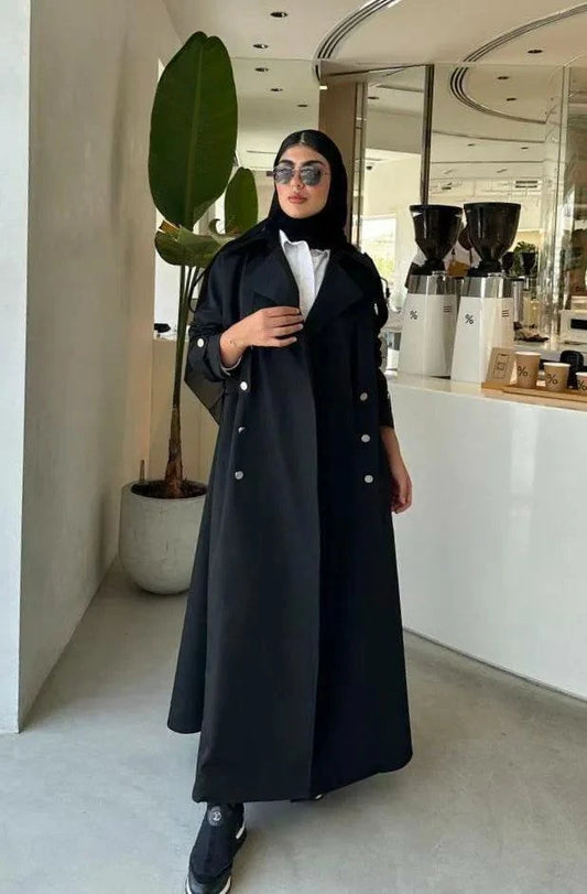 Modern black abaya with trench coat design, wide lapels, double-breasted silver buttons, and cuff details for a sophisticated look.