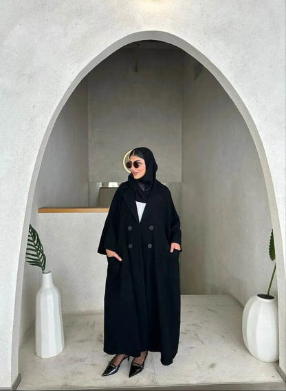 freesize black abaya in soft crepe fabric with front buttons and relaxed fit worn by woman in modern minimalist setting