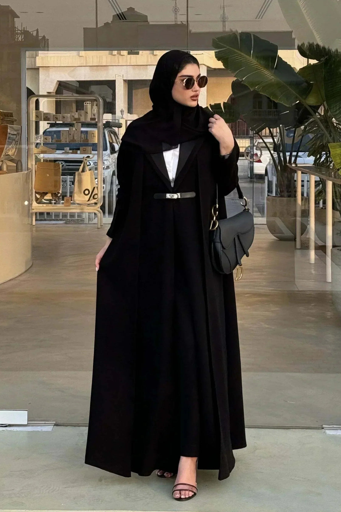 woman wearing chic black crepe and mokado fabric blazer with matching waist belt and sunglasses standing outdoors - chic blazer