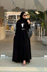 woman wearing chic black crepe and mokado fabric blazer with matching waist belt and sunglasses standing outdoors - chic blazer