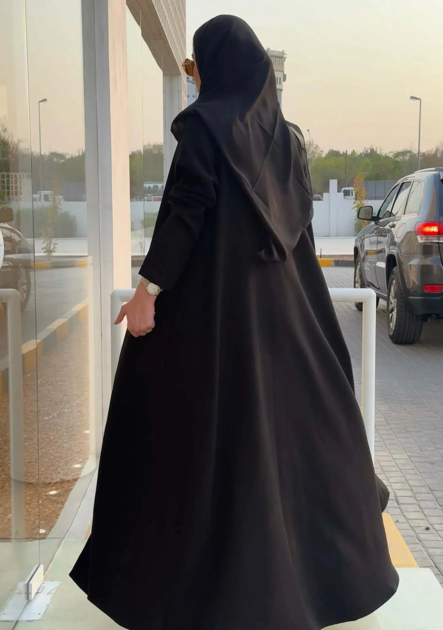 woman wearing chic black crepe and mokado fabric blazer with matching waist belt and sunglasses standing outdoors - chic blazer
