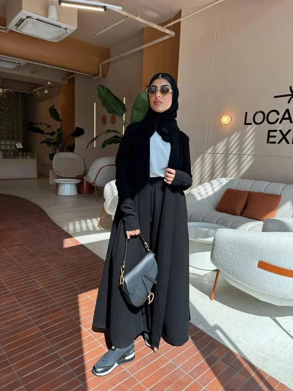 elegant black crepe abaya with subtle back pleats for graceful movement and minimalist front design