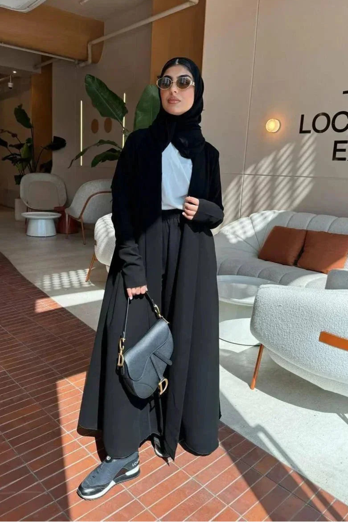 elegant black crepe abaya with subtle back pleats for graceful movement and minimalist front design
