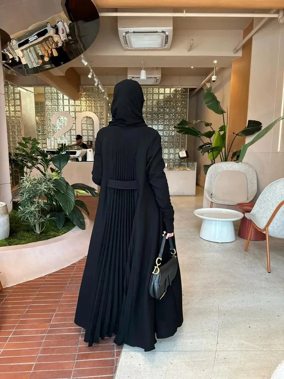 elegant black crepe abaya with subtle back pleats for graceful movement and minimalist front design