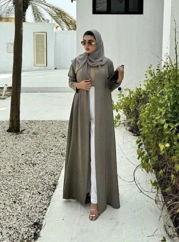 Velma abaya in dark beige light crepe with subtle texture and elegant natural tone worn with matching hijab and white pants