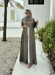 Velma abaya in dark beige light crepe with subtle texture and elegant natural tone worn with matching hijab and white pants
