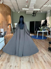 woman wearing flowing dark olive abaya in modern room with wooden floor - light olive abaya