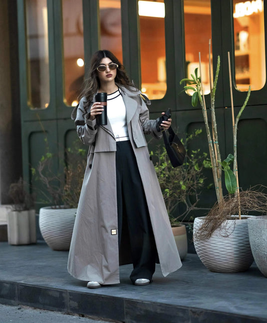 woman wearing modern classic trench coat with wide lapel collar and flowing silhouette outdoors