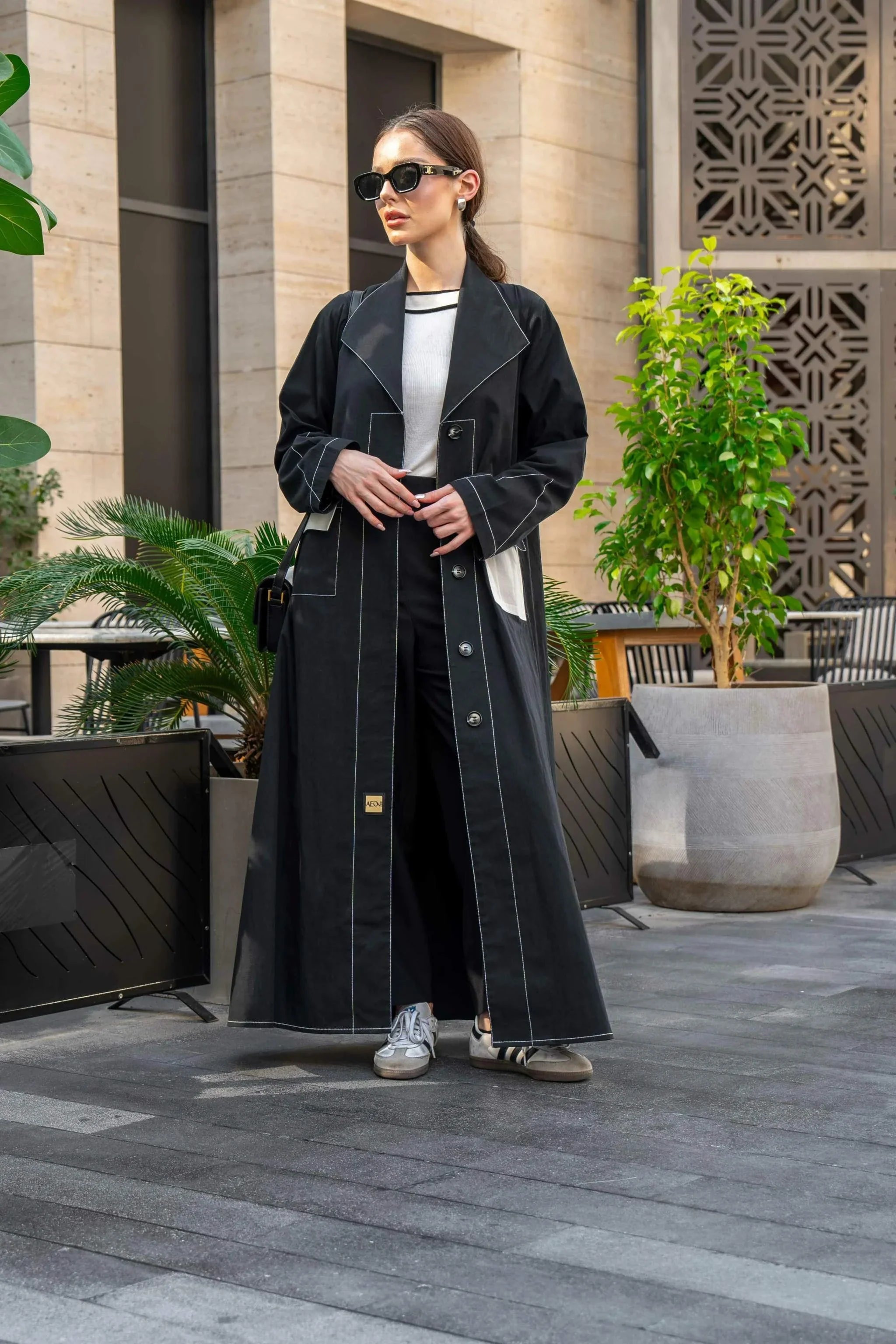 Chinoa black cloche-style abaya with structured A-line silhouette and flared hem in chino fabric for modern everyday wear