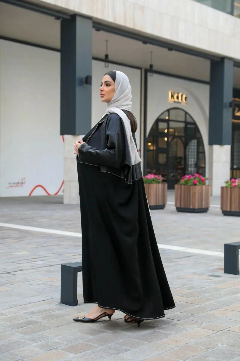 Modern black abaya with white stitching in premium mokado fabric for stylish comfort