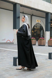 Modern black abaya with white stitching in premium mokado fabric for stylish comfort
