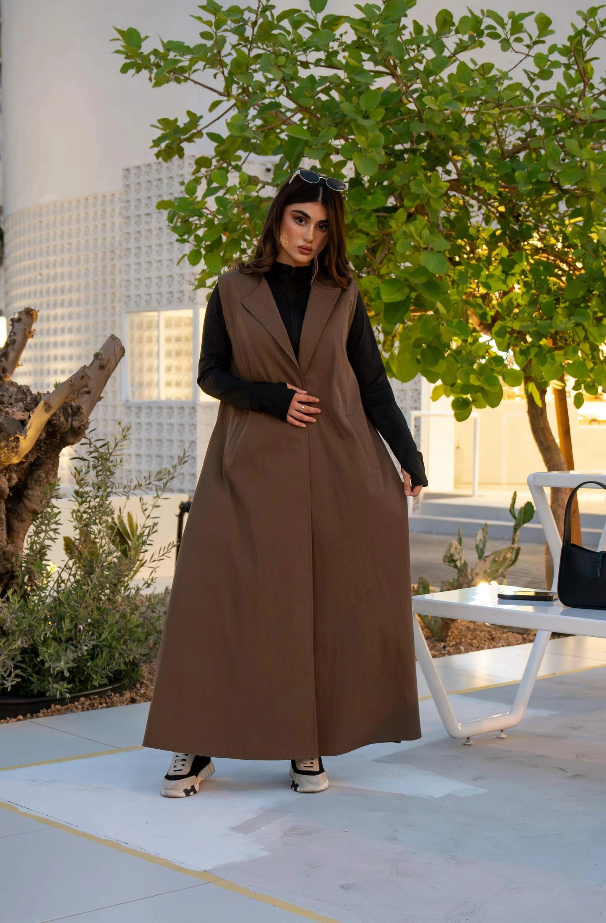 woman wearing chino brown cropped trench over sleeveless dress outdoors