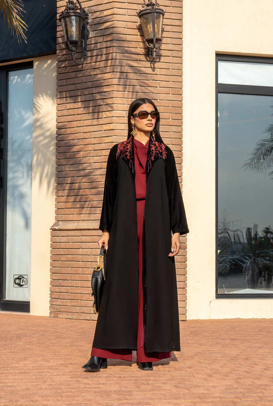 Crimza black crepe abaya with red velvet shak detailing on shoulders, elegant evening wear.