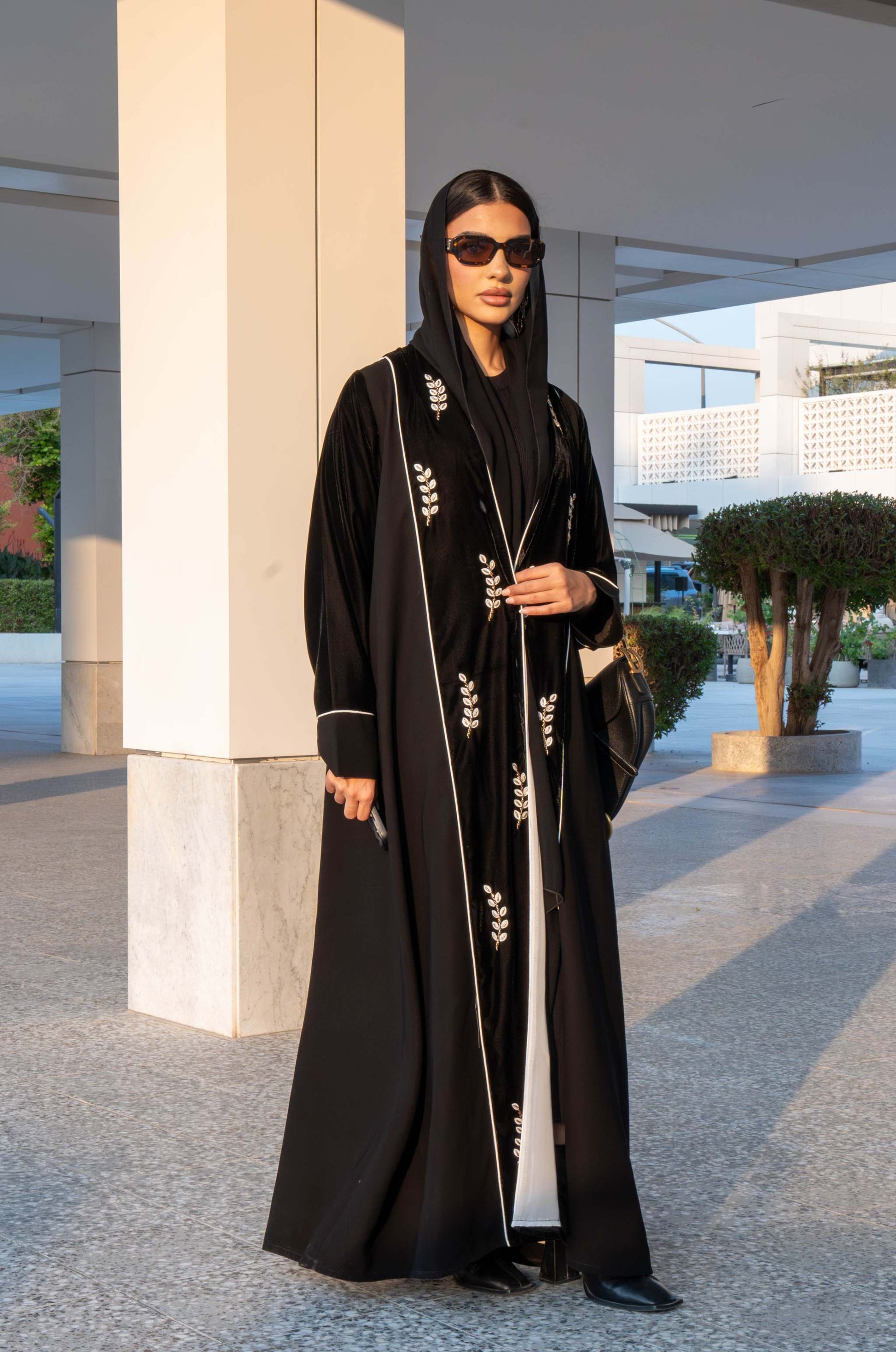 Elegant black Veloura Abaya with gold embroidery and velvet accents, perfect for special occasions.