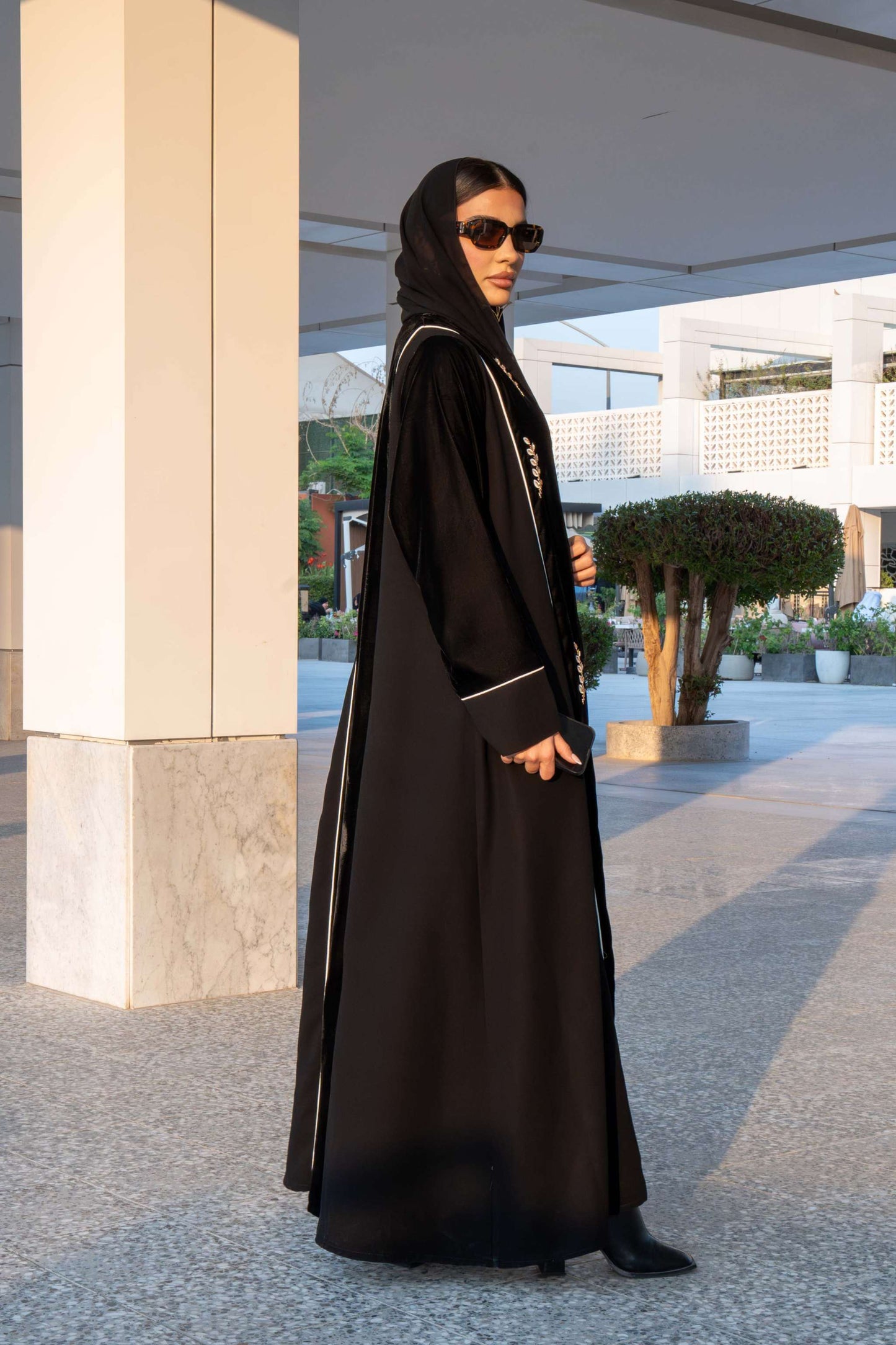 Elegant black Veloura Abaya with gold embroidery and velvet accents, perfect for special occasions.