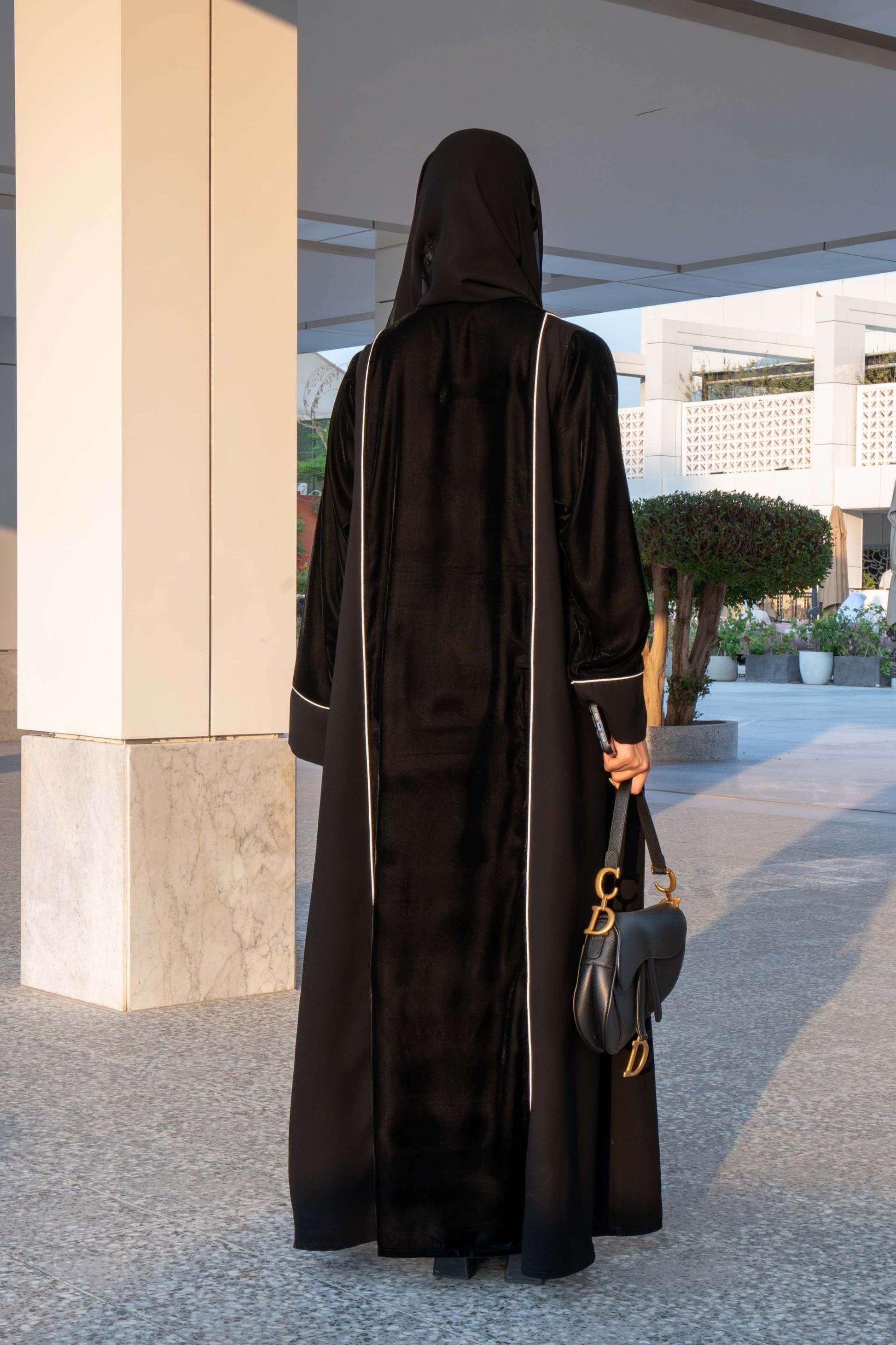 Elegant black Veloura Abaya with gold embroidery and velvet accents, perfect for special occasions.