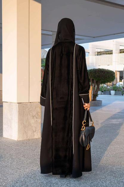 Elegant black Veloura Abaya with gold embroidery and velvet accents, perfect for special occasions.