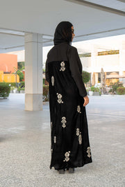Black Velvet Bloom abaya with elegant embroidery and loose bisht-style cut, combining velvet and crepe fabrics for a luxurious look