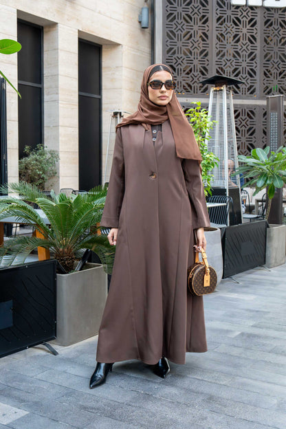 woman wearing classic brown crepe abaya with hijab and sunglasses outdoors carrying a small handbag
