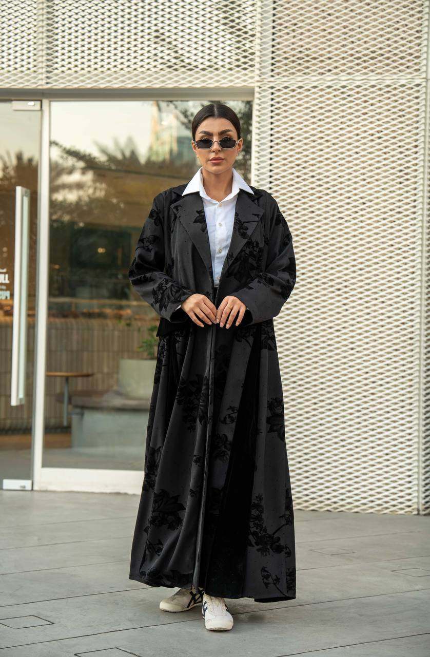 Black Velvet Rose abaya with subtle velvet floral pattern and classic lapel collar on a flowy silhouette.
