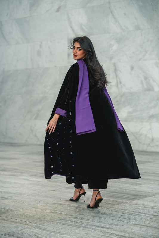 Black velvet abaya with silver and lilac star embroidery and soft purple lining for elegant occasions.