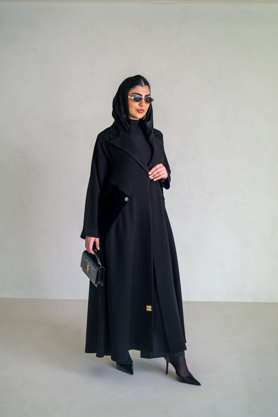Elegant black abaya with velvet lapels and asymmetrical overlay, perfect for evening occasions