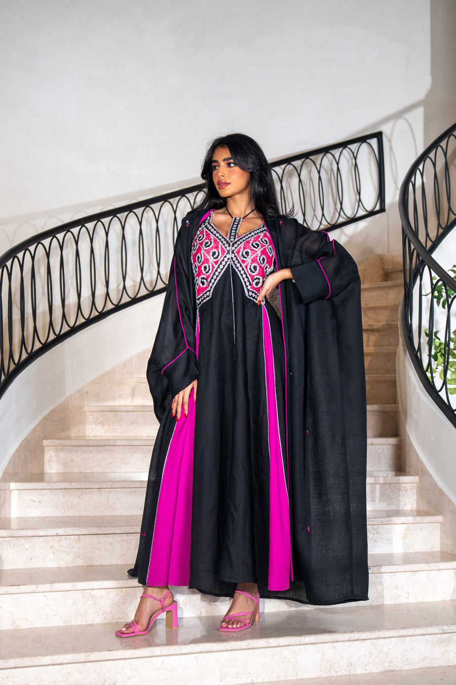 Black dress with magenta panels and butterfly-style embroidered neckline paired with matching black bisht with contrast piping