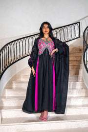 Black dress with magenta panels and butterfly-style embroidered neckline paired with matching black bisht with contrast piping