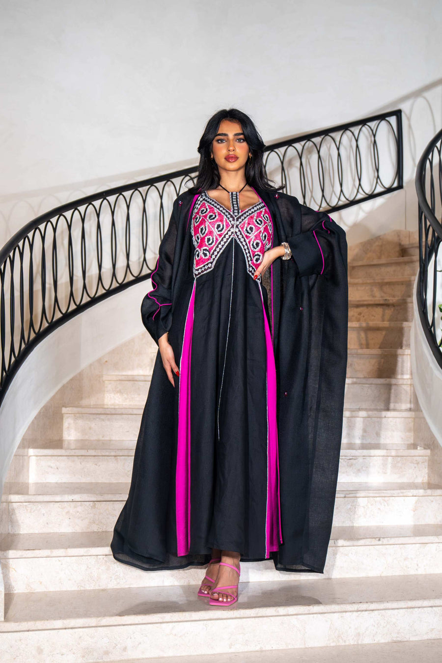 Black dress with magenta panels and butterfly-style embroidered neckline paired with matching black bisht with contrast piping