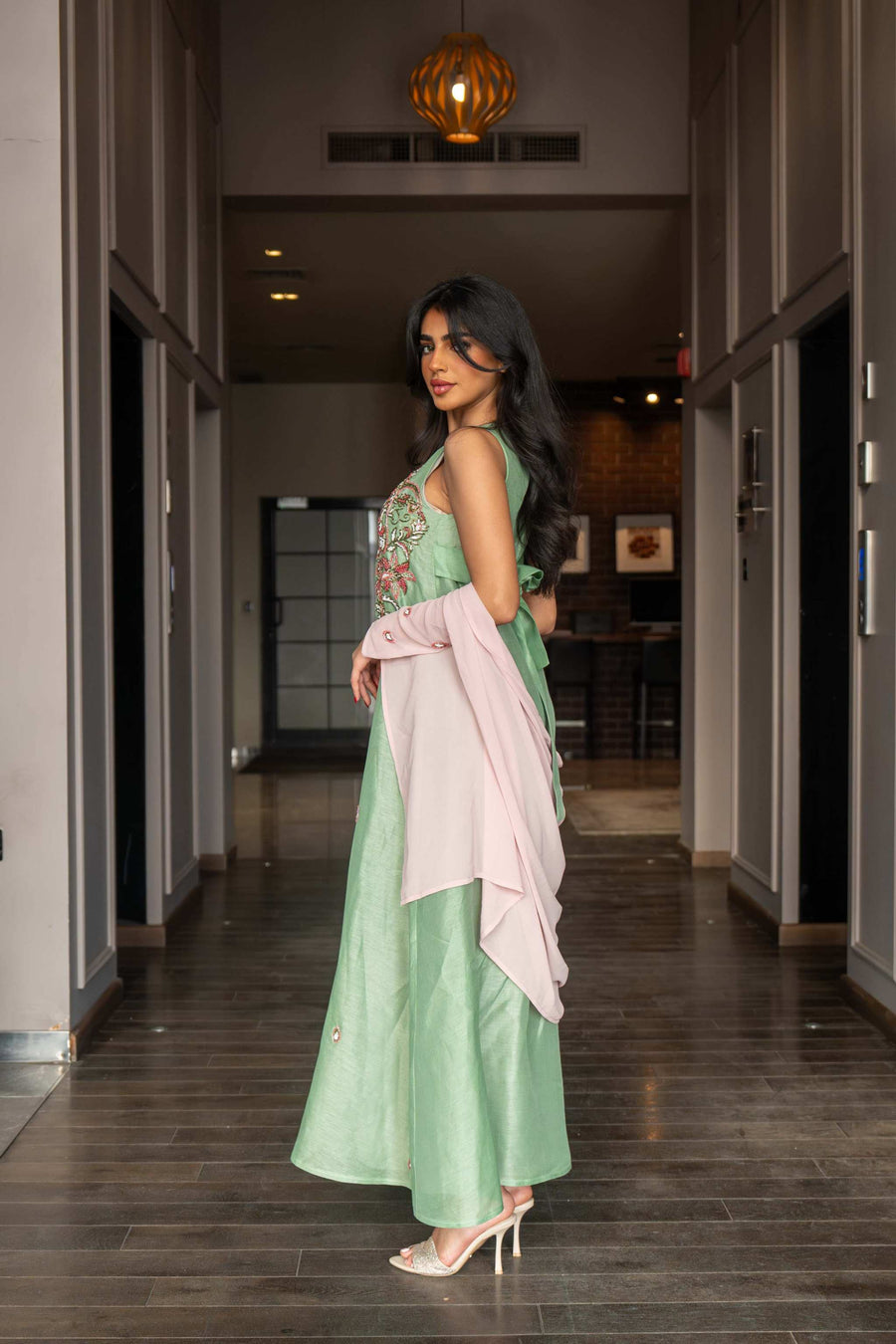 Soft pastel green one-piece dress with floral embroidery and flowing blush pink cape sleeves