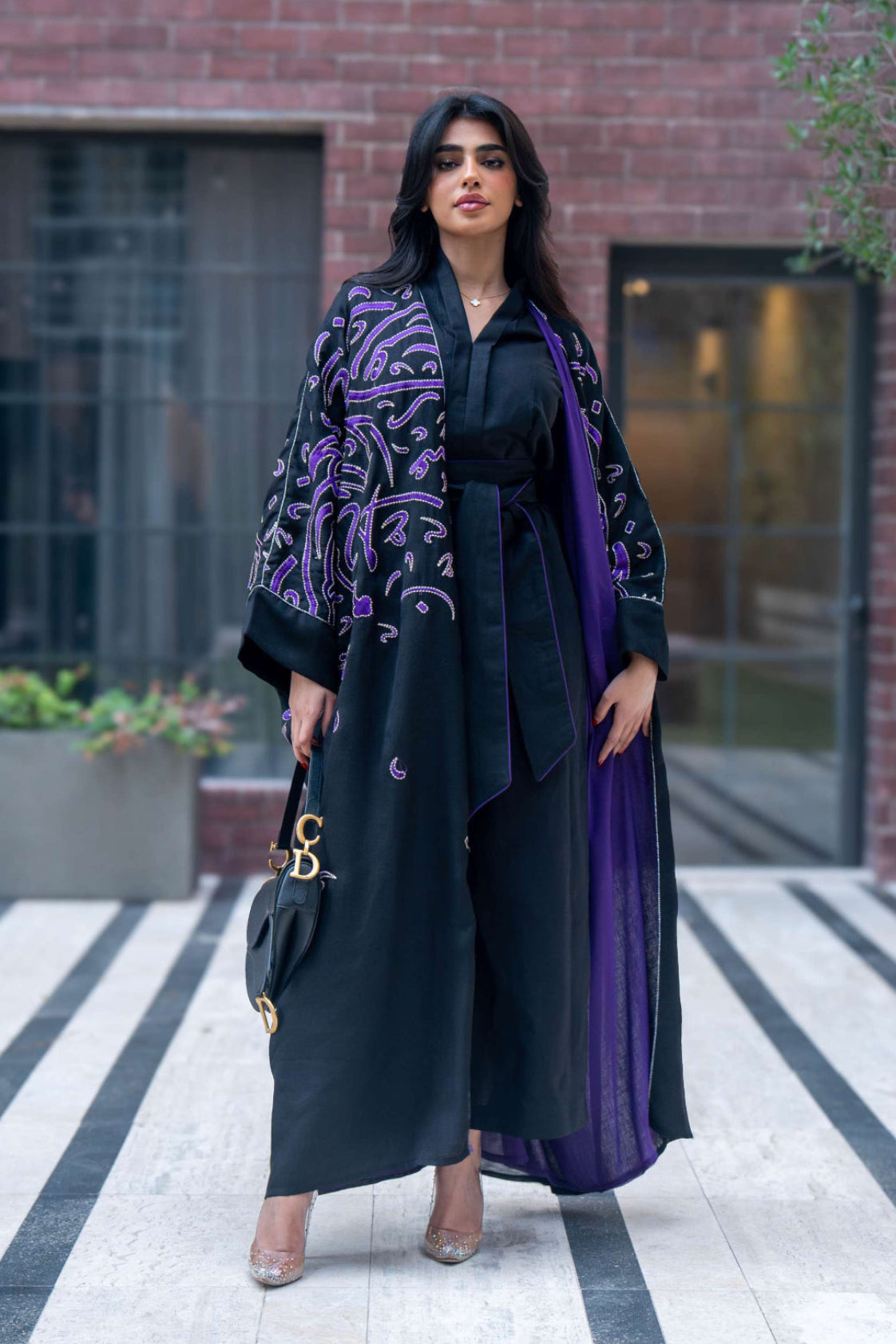 Elegant black bisht with purple chiffon lining and intricate purple Arabic calligraphy embroidery.