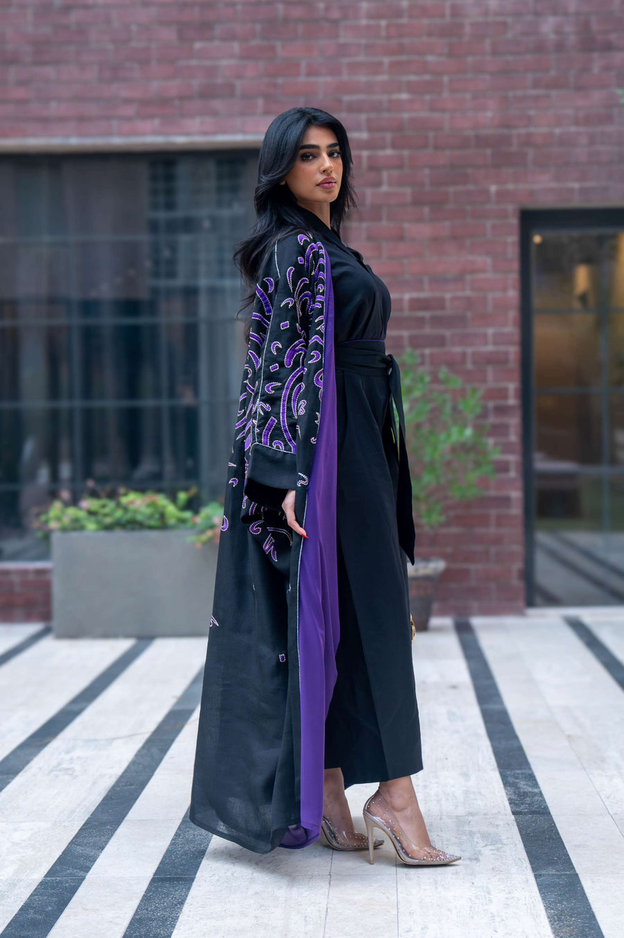 Elegant black bisht with purple chiffon lining and intricate purple Arabic calligraphy embroidery.