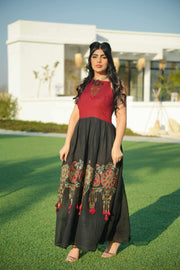Woman wearing black and red embroidered khesha fabric dress with bold red detailing and lightweight texture outdoors