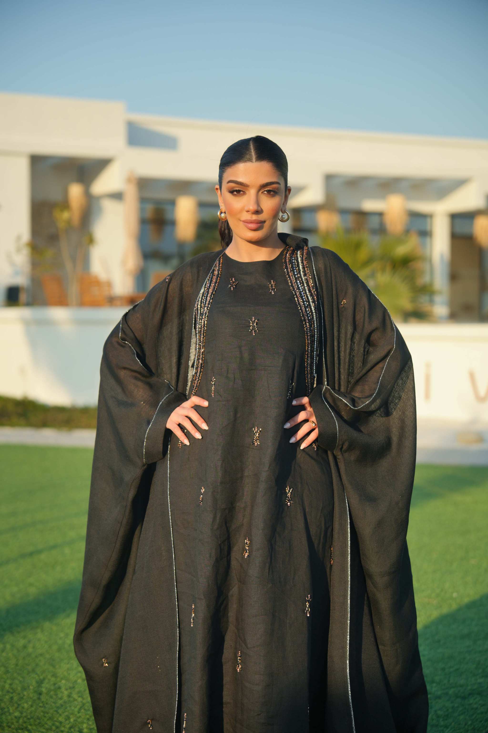 Elegant black Najm abaya with silver embroidery and flowing silhouette, perfect for formal evenings.