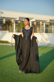 Elegant black abaya with delicate detailing layered over a shimmering silver and navy inner piece, perfect for evening occasions